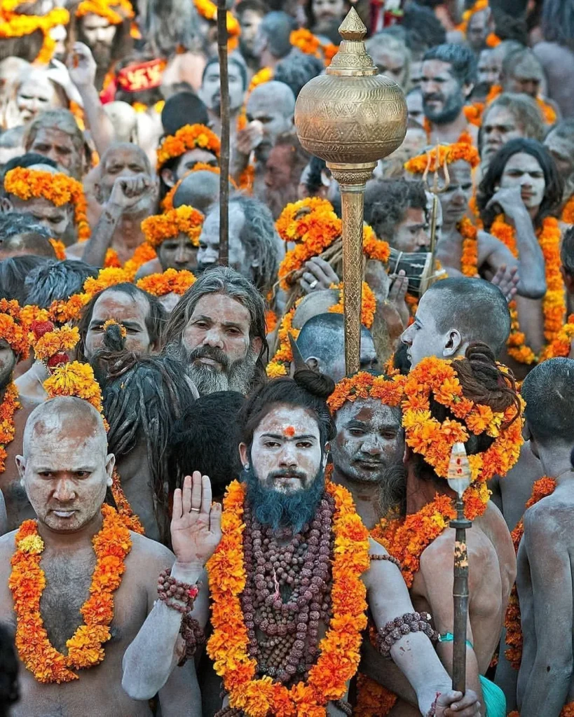 Naga Sadhu holding a trishul (trident) in one hand while draped with a towel (goda) around his waist. 