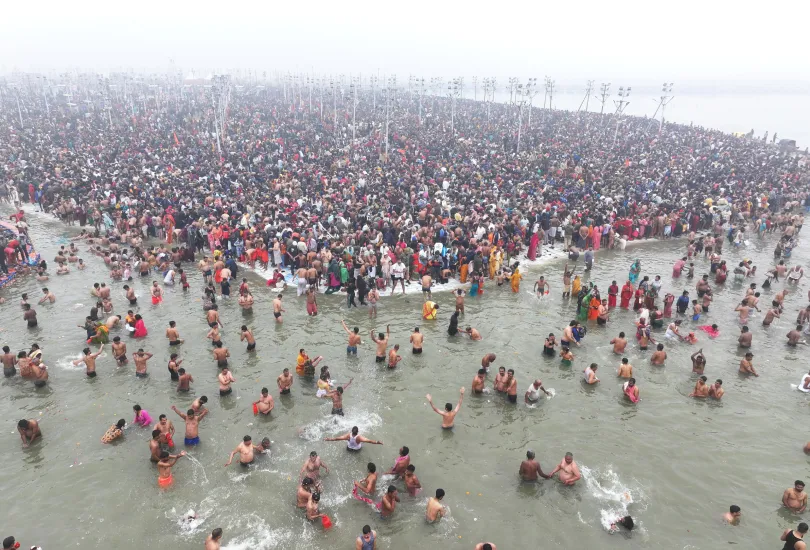 Devotees taking a holy dip at the Triveni Sangam during Kumbh Mela 2025 in Prayagraj, surrounded by a serene atmosphere of faith and spirituality