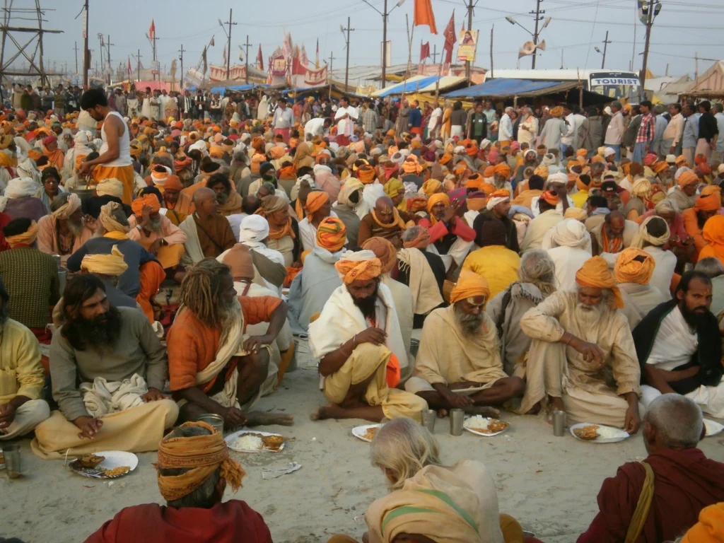 Devotees enjoying a meal together at the Kumbh Mela, surrounded by the vibrant atmosphere of the festival.